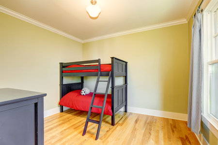 Empty boys bedroom with black bunk bed and red bedding. Hardwood floor and one window. Northwest,...