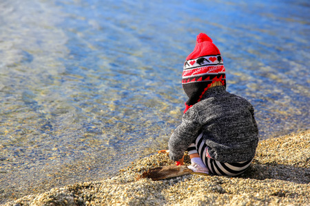 Little girl is playing by the water of Lake Wanaka in New Zealandの写真素材