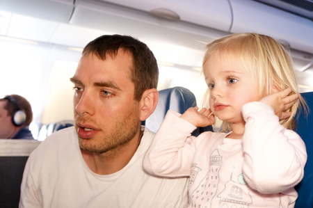 Young Father with his little daughter travel by planeの写真素材