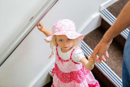 Charming little caucasian girl in pink floral dress looking upの写真素材
