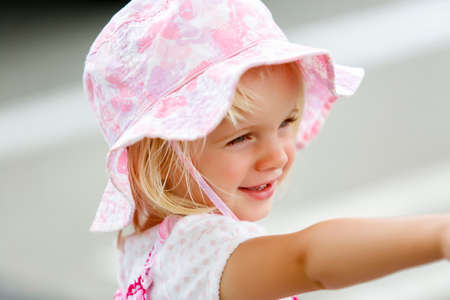 Charming little caucasian girl in pink hat smilingの写真素材