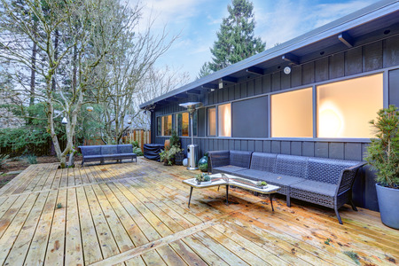View of large back deck with outdoor furniture overlooking grass filled backyard. Northwest, USAのeditorial素材