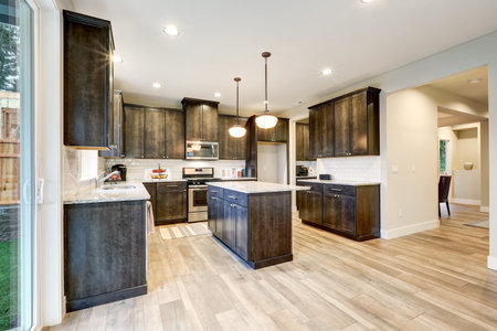 Light filled Northwest kitchen design with kitchen island, natural brown cabinets topped with...