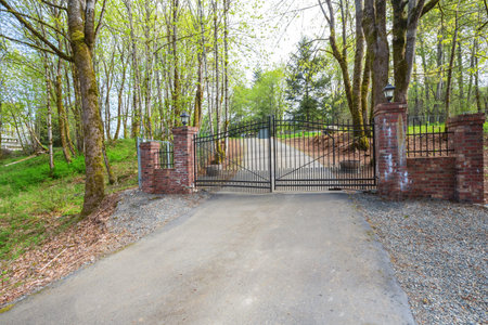 Wrought iron driveway gates with red brick columns leading to a beautiful secluded home. Northwest,...