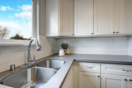 White and gray kitchen room with modern stainless steel appliances,  quartz countertops and subway tile backsplash.の写真素材