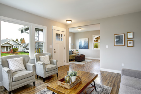 Spacious living room with light gray walls and large window.の写真素材