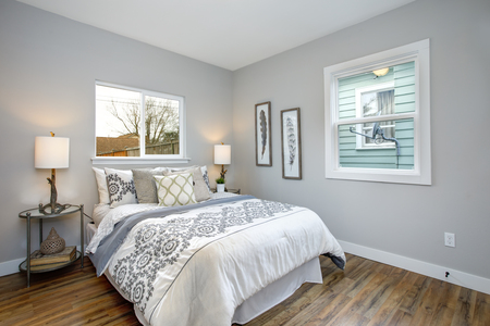 Beautiful gray and white bedroom with embroidery pattern bedding set.の写真素材