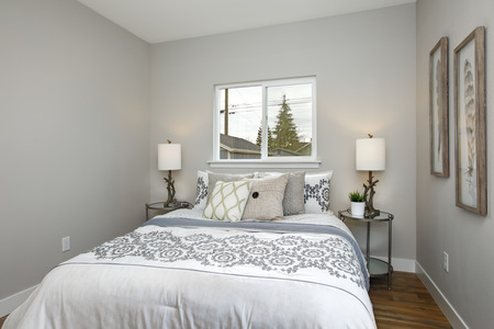 Beautiful gray and white bedroom with embroidery pattern bedding set.の写真素材