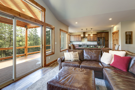 Light living room interior with leather sofa and view of spacious deck.の写真素材
