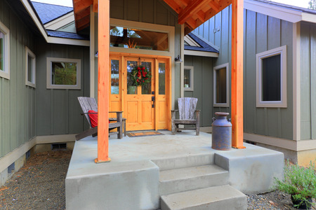 Welcoming entrance porch with wooden front door decorated with Christmas wreathの写真素材