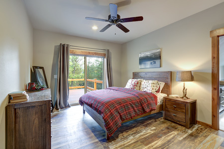 Restful country master bedroom furnished with wooden bed, nightstand and dresserの写真素材