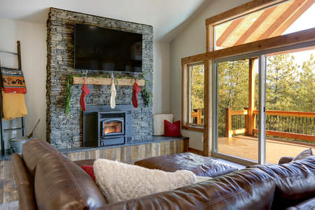 Living room interior with stone fireplace, Christmas decor and deck.の写真素材
