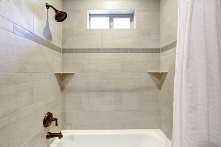 White and fresh bathroom interior with ivory subway tile shower surround .の写真素材