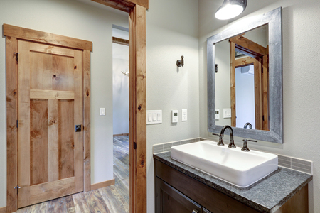 White and fresh bathroom interior with a rectangular vessel sink and dark gray countertop.の写真素材