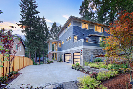 Modern house exterior with two car garage, spacious driveway and nice landscapeの写真素材