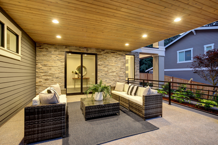 Luxury covered patio with stone fireplace and cozy interiorの写真素材