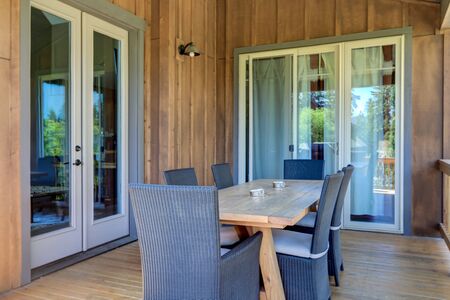 Great wooden rustic deck with solid dining room table with chairs.の写真素材