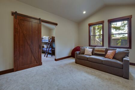 Large family game fun room with tall vaulted ceiling and large double windows, beautiful natural tones furnitutre and large TV. Ceiling fan and doors open to other rooms.の写真素材