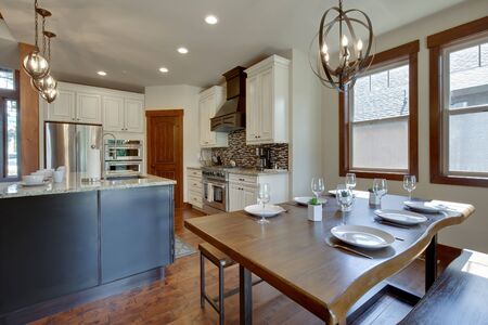 An absolute beautiful luxury living room with huge vaulted  ceiling, fire place, harwood floor, amazing furniture, and lots of windows and doors. Solid wood rustic modern dining room table. open concept.の写真素材