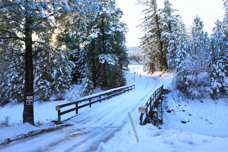 SNow covered beautiful old American rustic country side landscape with bridge, trail and water canal. Peaceful and inspiring.の写真素材