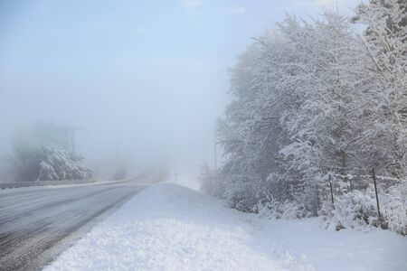 Winter old American Country side landscape with rustic houses, cars and fences covered in snow.の写真素材