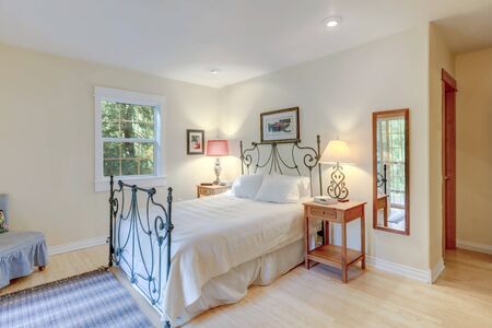 Bedroom bright interior with metal bed and sliding door to the balcony with chair, country style of American cozy home with light bamboo flooring.の写真素材