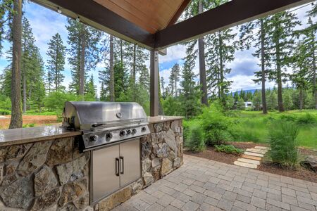 Beautiful back yard stone and brick patio with BBQ grill and luxury futniture.の写真素材