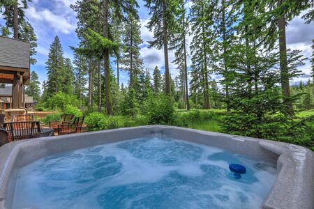 Open hot tub in the back yard with forest and golf course near luxury homes.の写真素材