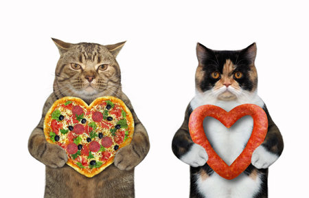 There are two cats. The first is holding a heart shaped pizza and the second sausage. White...