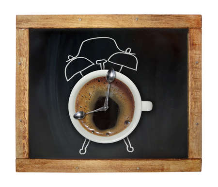 A cup of coffee looks like an alarm clock. It is on a school blackboard. White background. Isolated.の写真素材