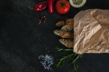 Fry sardines. Omega 3. Fish with herbs. Mediterranean fish. roast, broi, grill fish packaged in paper with vegetables and spices aroundの写真素材