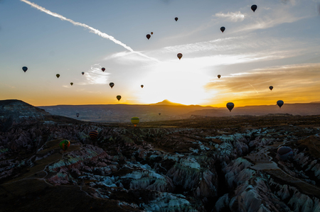 Hot air balloon flying over valleys in Cappadocia Turkey.の写真素材