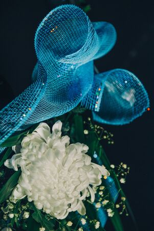 white chrysanthemum bouquet with blue mesh decorationの写真素材