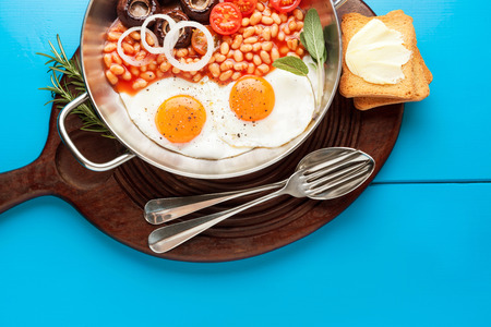 Full English Breakfast with fried eggs, beans, toasts, tomatoes , mushroomsの写真素材