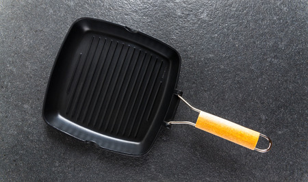 Empty new grill pan on a stone dark backgroundの写真素材
