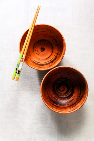 empty bowls and chopsticks on white stone backgroundの写真素材