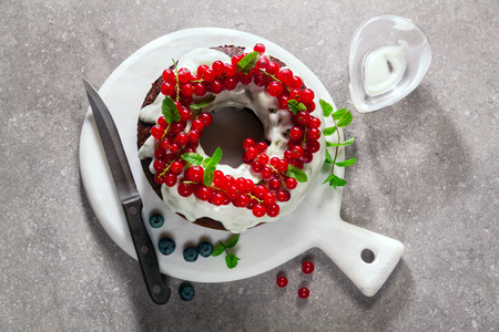 bundt cake with fresh berries and sauce from sour cream on grey stone tableの写真素材