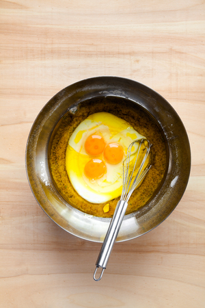 eggs and whisk in a large metal bowl. cooking dough for pie or muffinsの写真素材