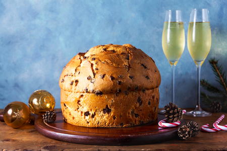 Italian festive bread panetton on a table decorated for Christmas. and two glasses of champagne. New Year's traditional dessertの写真素材