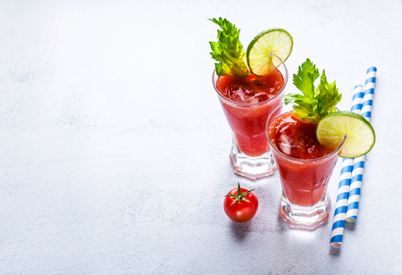 Cocktail Bloody Mary with ice in glasses on a stone tableの写真素材