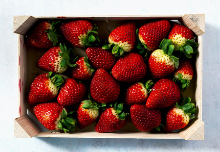 Pile of juicy ripe organic strawberries in a wooden box. sale on the market の写真素材
