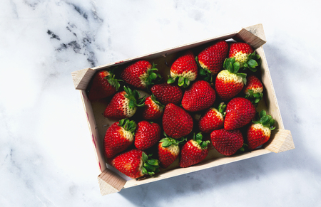 Pile of juicy ripe organic strawberries in a wooden box. sale on the market の写真素材
