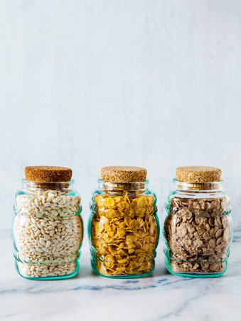 Variety of cold quick breakfast cereals in glass jars , healthy eating for kids and athletes....
