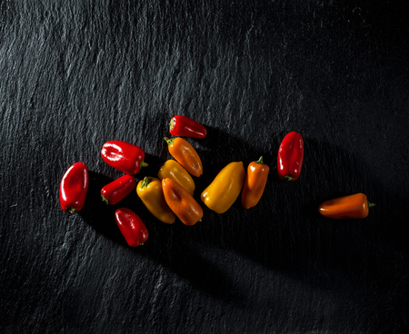 colored sweet pepper on black slate. background of food. organic vegetables. copy spaceの写真素材