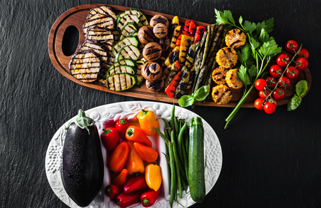 grilled vegetables on a wooden tray on a black slate. copy space, overhead shotの写真素材
