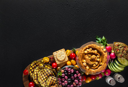 fresh vegetables on wooden board over black background. Clean eating