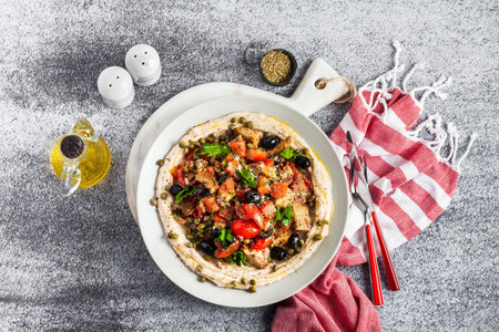 vegan panzanella salad on a layer of hummus on a plate. tasty healthy food.の写真素材