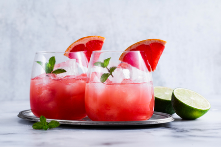 alcoholic cocktail Paloma of grapefruit and ice in glasses on a marble table . refreshing drink with lime juiceの写真素材