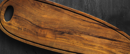 banner of Empty wooden long board for serving appetizers on a black slate table. copy spaceの写真素材