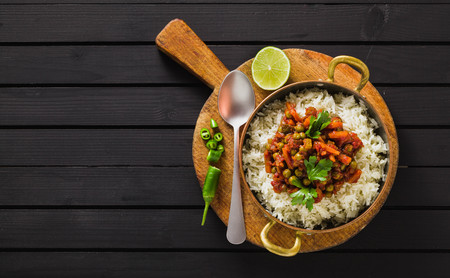 vegan curry with green peas and basmati rice served on a wooden table tray, healthy Indian comfort foodの写真素材